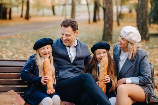 A large family is sitting on a bench in an autumn park. Happy people in the autumn park.