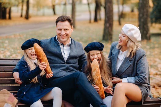 A large family is sitting on a bench in an autumn park. Happy people in the autumn park.