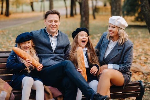 A large family is sitting on a bench in an autumn park. Happy people in the autumn park.