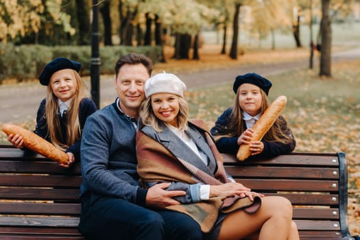 A large family is sitting on a bench in an autumn park. Happy people in the autumn park.