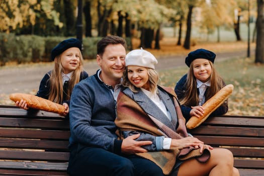 A large family is sitting on a bench in an autumn park. Happy people in the autumn park.