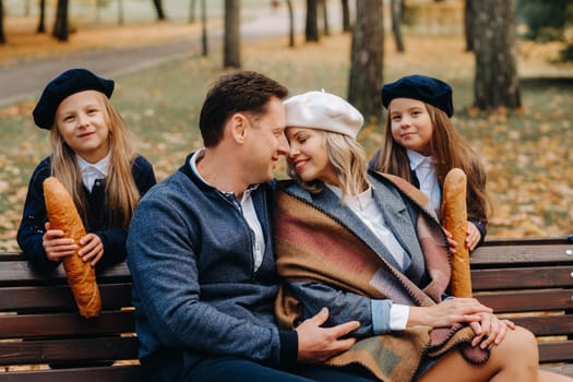 A large family is sitting on a bench in an autumn park. Happy people in the autumn park.