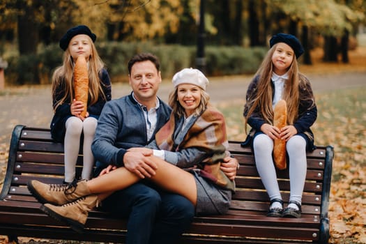 A large family is sitting on a bench in an autumn park. Happy people in the autumn park.