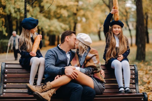 A large family is sitting on a bench in an autumn park. Happy people in the autumn park.