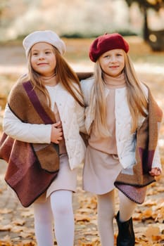 Happy children cuddling in a beautiful autumn park.