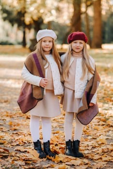 Happy children cuddling in a beautiful autumn park.