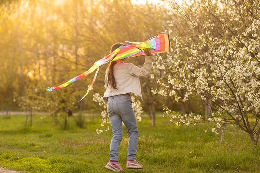 little cute girl flying a kite on a sunny day.