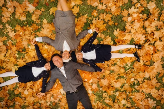 A large family holding hands are lying in an autumn park .Happy people in the autumn park.