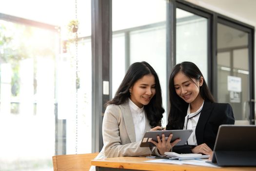 Two Young Asian businesswoman discuss with new startup project Idea presentation, analyze planning and financial statistics and investment market at office..