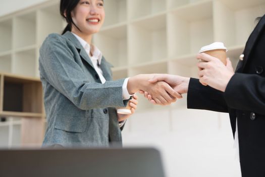 Handshake of businesspeople. Two asian female hand makes a handshake in the office.