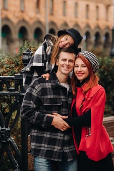 A stylish family of three strolls through the autumn city posing for a photographer . Dad, mom and daughter in the autumn city.