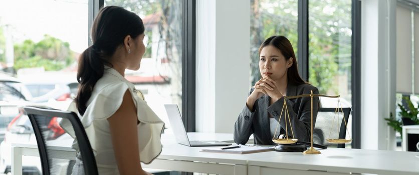 Asian female lawyer discussing negotiation legal case with client meeting with document contact in courtroom, law and justice concept.