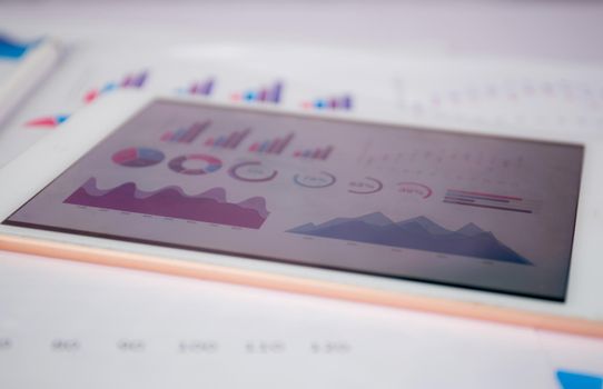 Report graph and chart of investment with finance on tablet computer on desk, datum of stock and growth, planning and statistic with economic, no people, digital marketing, business concept.