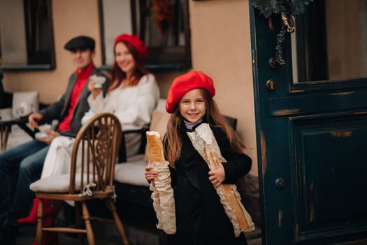 A stylish girl with baguettes stands near the store against the background of her parents.