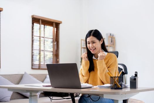 young business woman got overjoyed by good news and started celebrating while working on laptop - Concept of new Job offer or promotion, college admission and loan approvel or won the price money.