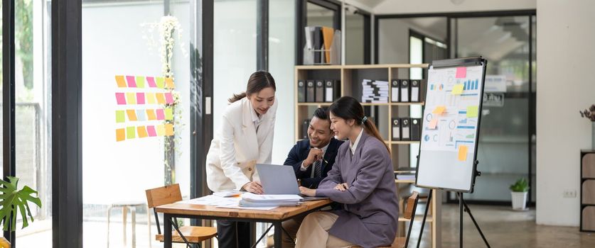 Group of young business people working and communicating while sitting at the office desk together with colleagues. Project and Business concept