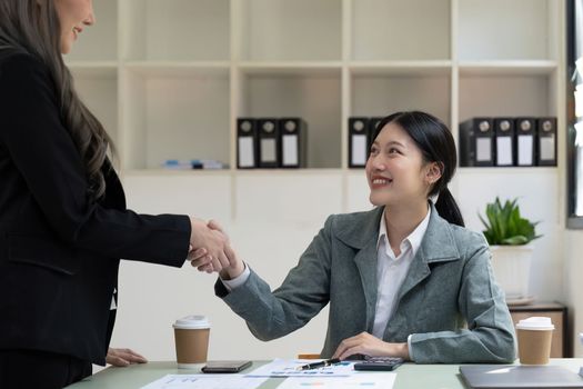 Welcome to our team. close up young modern women shaking hands while working in the creative office.