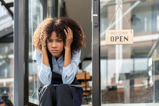 black woman waiter of street cafe is waiting for clients, customersm she is bored, no people in their cafe. small business owner