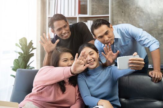 Friends watch sports on TV, cheer and celebrate. Happy diverse asian friend supporters fans sit on couch with popcorn and drinks.
