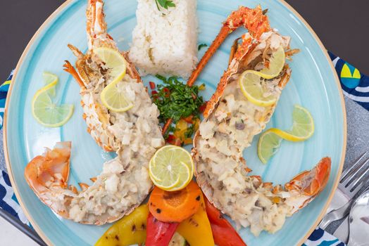 Stuffed lobster dish a la carte meal with white rice and vegetables at restaurant table setting