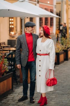 Portrait of a happy couple walking on the street in an autumn city. Stylish couple in retro style in autumn in the city.