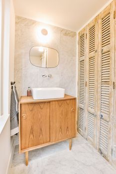 a bathroom with wooden shutters on the wall and white marble flooring in the shower stall is next to the sink