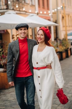 Portrait of a happy couple walking on the street in an autumn city. Stylish couple in retro style in autumn in the city.