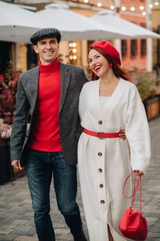 Portrait of a happy couple walking on the street in an autumn city. Stylish couple in retro style in autumn in the city.