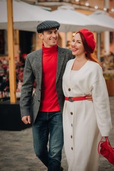 Portrait of a happy couple walking on the street in an autumn city. Stylish couple in retro style in autumn in the city.