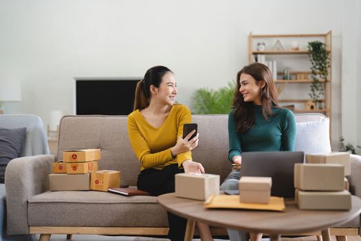 Two women busines startup for online marketing, Entrepreneur packing boxes parcels for shipping, SME sellers, and freelance online sales concept.