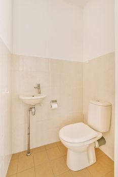 a bathroom with tile flooring and white wall tiles on the walls, toilet is in the center of the room