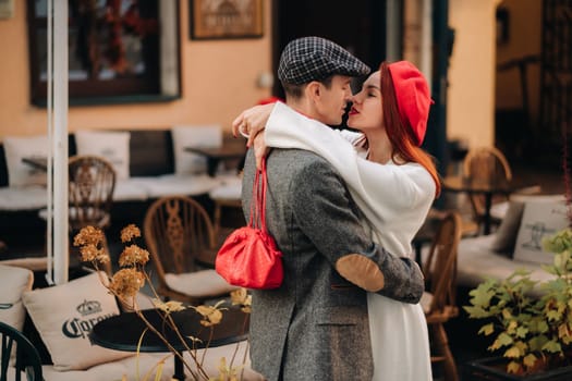 Portrait of a happy couple hugging on the street in an autumn city. Retro stylish couple in autumn in the city.