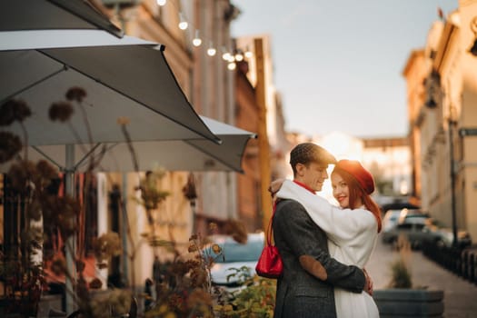 Portrait of a happy couple hugging on the street in an autumn city. Retro stylish couple in autumn in the city.