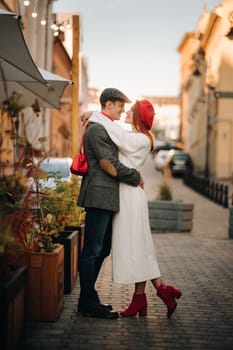 Portrait of a happy couple hugging on the street in an autumn city. Retro stylish couple in autumn in the city.