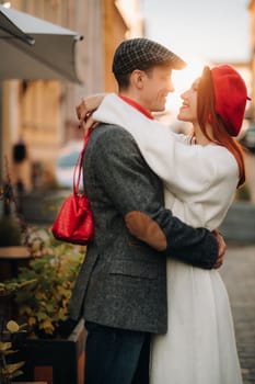 Portrait of a happy couple hugging on the street in an autumn city. Retro stylish couple in autumn in the city.