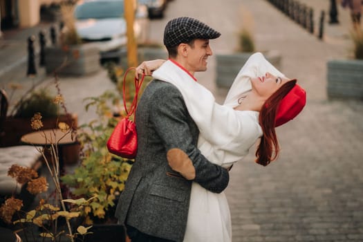Portrait of a happy couple hugging on the street in an autumn city. Retro stylish couple in autumn in the city.