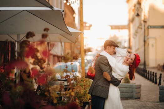 Portrait of a happy couple hugging on the street in an autumn city. Retro stylish couple in autumn in the city.