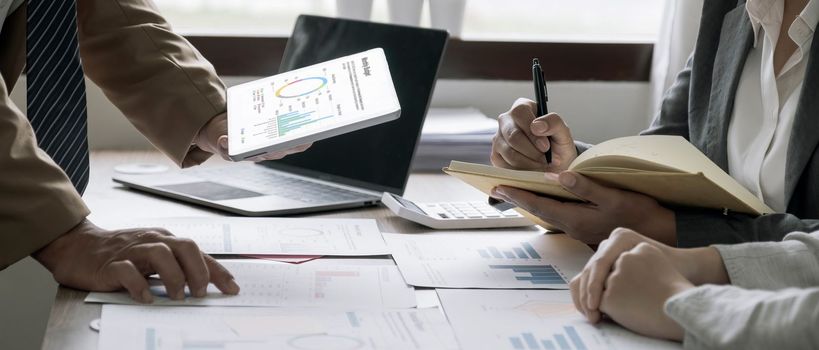 Business People Meeting using laptop computer,calculator,notebook,stock market chart paper for analysis Plans to improve quality next month. Conference Discussion Corporate Concept.