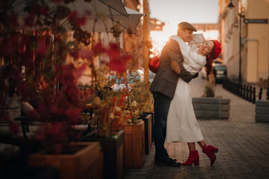 Portrait of a happy couple hugging on the street in an autumn city. Retro stylish couple in autumn in the city.