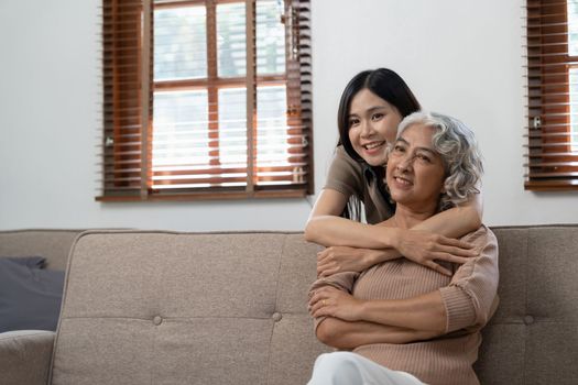 smiling grownup daughter hugging older mother. two generations concept, beautiful young woman embracing mature woman, posing for photo together