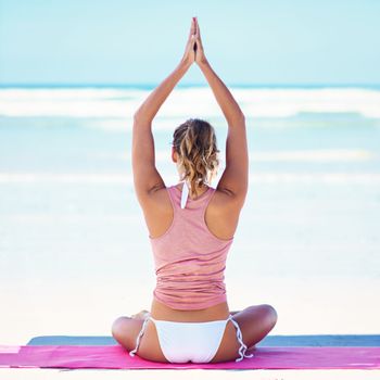 Meditation is the key to enlightenment. a young woman doing yoga at the beach