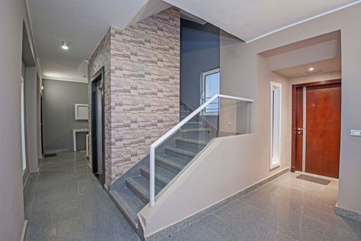 Interior design of apartment building stairwell area with steps and doors