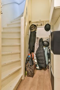 the inside of a house with clothes and bags on the floor in front of the staircase leading up to the stairs