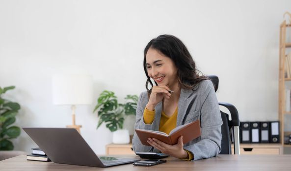 Portrait of an Asian young business Female working on a laptop computer in her workstation.Business people employee freelance online report marketing concept