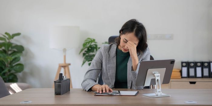 asian woman thinking hard concerned about online problem solution looking at laptop screen, worried serious asian businesswoman focused on solving difficult work computer task..