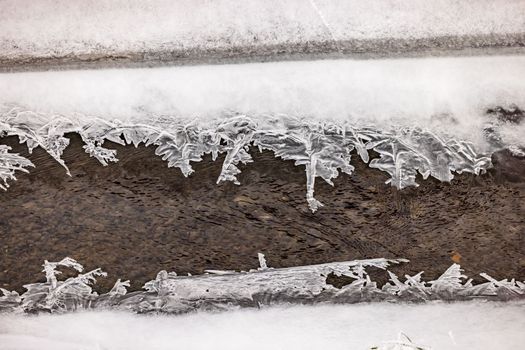 Beautiful ice crystals in different shapes on a stream in winter with high depth of field