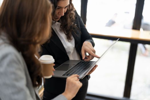 Diverse businesspeople cooperate work together discussing company financial statistics, multiracial colleagues collaborate brainstorm with finance on tablet