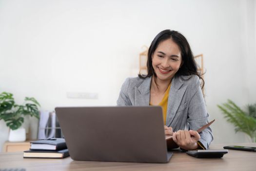 Portrait of an Asian young business Female working on a laptop computer in her workstation.Business people employee freelance online report marketing concept