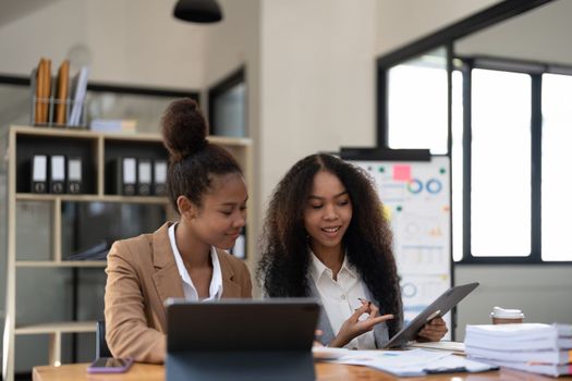 diverse coworkers working together in boardroom, brainstorming, discussing and analyzing and planning business strategy