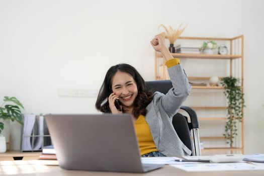 Happy excited asian woman celebrate with computer laptop, success or happy action. Freelancer or Entrepreneur using technology and start up modern home